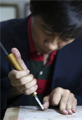 Carver Lu Min works on registration. (Photo by Feng Yongbin/China Daily)
