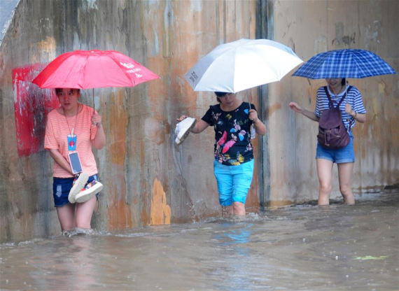 Pedestrians walk on a flooded street in Jiujiang, east China's Jiangxi Province, June 1, 2016. Torrential rain hit the city and caused flood. (Photo: Xinhua/Hu Guolin)