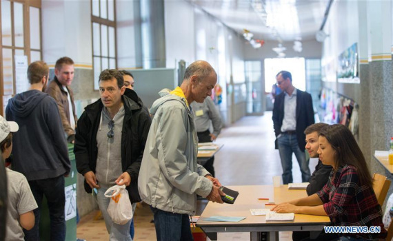 People prepare to vote at a polling station in Geneva, Switzerland, on June 5, 2016. Swiss people voted on Sunday on whether to give every adult citizen a basic guaranteed monthly income of 2,500 Swiss francs ($2,560). (Photo: Xinhua/Xu Jinquan)