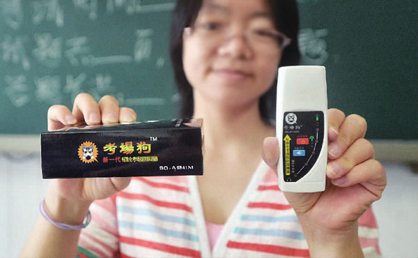 An exam supervisor at Beijing Dongzhimen High School shows a monitoring device that can detect invisible earpieces used for cheating. The school is one of this year's gaokao sites. (LIU CHANG/CHINA DAILY)