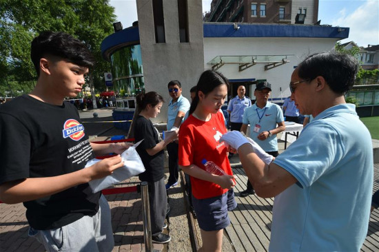 Staff members check identity of candidates at an exam site of the national college entrance exam at the Mingzhu School of the Middle School affliated to the Northeast Normal University in Changchun, capital of northeast China's Jilin Province, June 7, 2016. (Xinhua/Xu Chang)
