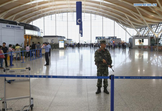 An armed policeman stands guard at the site where an explosion happened at Shanghai Pudong International Airport in east China's Shanghai, June 12, 2016. Three passengers were injured after an explosion at Shanghai Pudong International Airport on Sunday afternoon, authorities said. (Phto: Xinhua/Ding Ting)