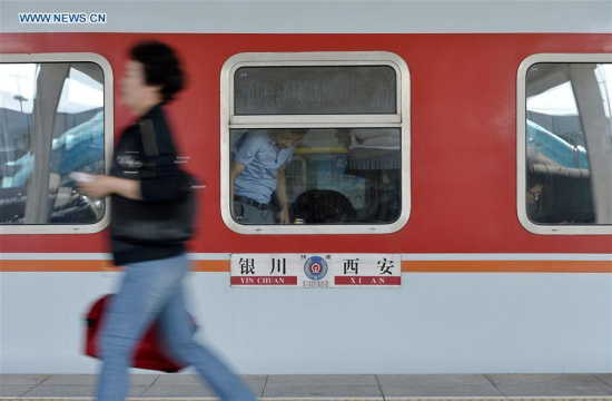 A passenger prepares to board a train at the railway station in Yinchuan, capital of northwest China's Ningxia Hui Autonomous Region, June 8, 2016. The number of passengers in Yinchuan railway station increased on Wednesday, one day before the 3-day holiday of the Dragon Boat Festival, or Duanwu Festival. (Xinhua/Peng Zhaozhi)