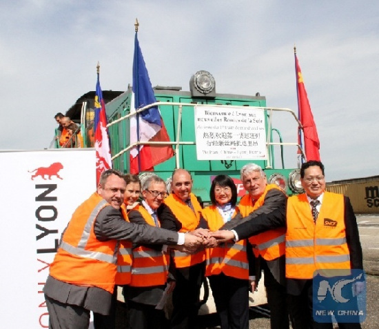 Photo taken on April 21, 2016, shows Chinese and French officials pose for a group photo in front of a freight train from Wuhan, China, upon its arrival for the first time at the freight railway station in Saint-Priest, outside Lyon, south-eastern France. (Photo: Xinhua/Zheng Bin)