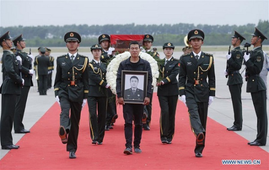 Shen Mingming (C), elder brother of Chinese UN peacekeeping soldier Shen Liangliang, escort the coffin of Shen Liangliang to the hearse at Longjia Airport in Changchun, capital of northeast China's Jilin Province, June 9, 2016. (Photo: Xinhua/Yin Gang)