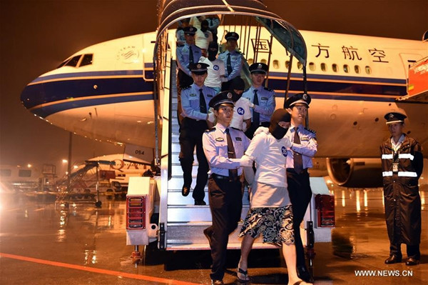 Suspected telecom fraudsters are escorted from an aircraft by police at Guangzhou Baiyun International Airport in Guangzhou, Guangdong province, on April 30. Ninety-seven suspects, including 32 people from Taiwan, were repatriated from Malaysia under the escort of Chinese police. The suspects were allegedly involved in more than 100 international telecom frauds in more than 20 areas of the Chinese mainland. (Liang Xu / Xinhua)