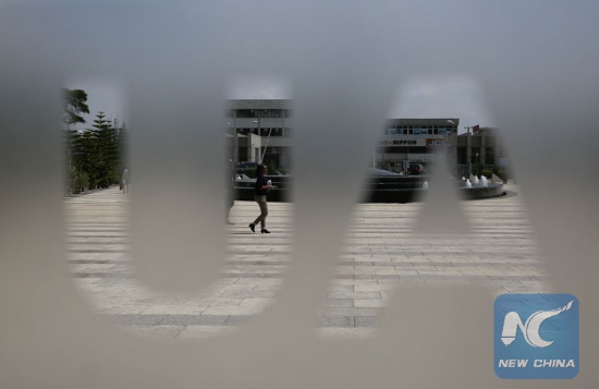 A woman walks outside the African Union (AU) Headquarters in Addis Ababa, capital of Ethiopia, on Jan. 28, 2016. (Photo: Xinhua/Pan Siwei)