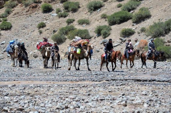 Nomadic herdsmen are on journey to take livestock to a summer pasture in the Kazak Autonomous County of Barkol, northwest China's Xinjiang Uygur Autonomous Region, July 8, 2015. (Photo: Xinhua/Zhang Jiangang)