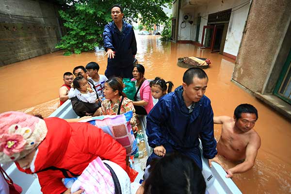 Rescuers evacuate people stranded in floods in Hengshan county, Hunan province, on Wednesday. More than 80,000 residents were affected, including 1,700 who were evacuated. (Peng Bin / For China Daily)