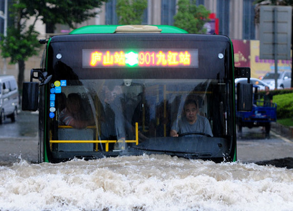 A bus makes its way through floodwaters in Jiujiang, Jiangxi province, on Sunday. (Photo: China Daily/Hu Guolin)