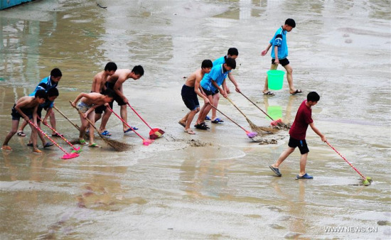 Teachers and students clear silts at a middle school in Tonggu Township of Youyang County, southwest China's Chongqing Municipality, June 20, 2016. (Xinhua/Chen Bisheng)