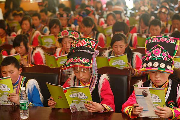 Students from the Qiang ethnic group study the regional textbook in Sichuan province. CHINA DAILY