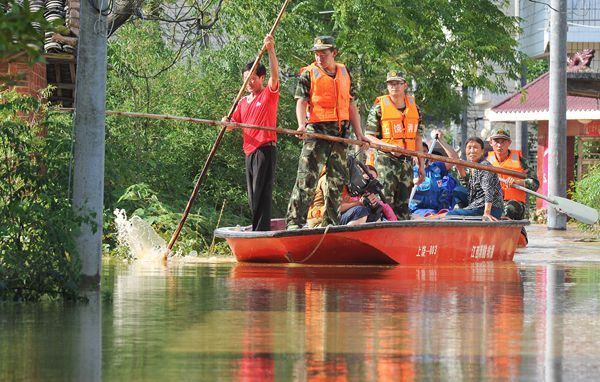 Firefighters search for people stranded in the floods in Poyang county, Jiangxi province, on Tuesday. (WANG QI/CHINA DAILY)
