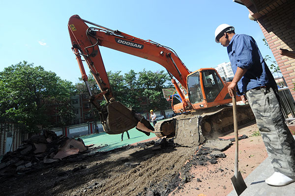 Synthetic tracks at the Baiyun Road Campus of Beijing No 2 Experimental Primary School were dismantled on Friday after parents complained that their children were poisoned by chemicals emitted by the material. WEI TONG/CHINA DAILY