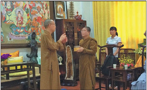 The abbot of Liuzu Temple (left) talks with Sim Sokhaya, who is pursuing a masters degree in Chinese history at South China Normal University in Guangzhou. Xu Jingxi / China Daily