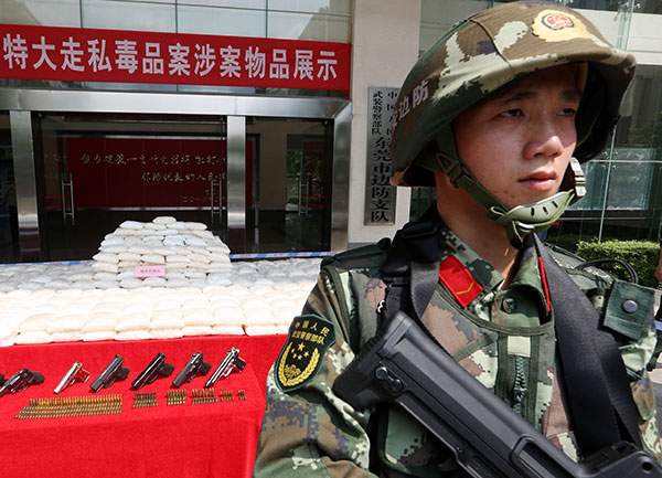 Guangdong police show methamphetamine, guns and ammunition that they seized during a crackdown on drug smuggling, in May. (CHEN FAN/CHINA DAILY)