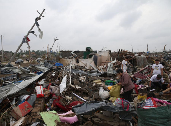 Villagers search for valuable things and clean debris of their homes at Beichen village in Funing county, Yancheng, Jiangsu province, on June 24, 2016. (Photo/Xinhua)