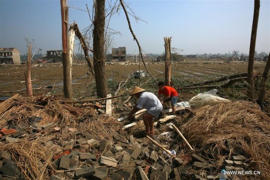 Villagers clear off debris in Danping Village of Chenliang Township in Funing County of Yancheng City, east China's Jiangsu Province, June 25, 2016. 