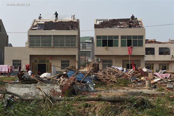 Villagers repair their damaged roof at Jiqiao Village under Shuoji Township in Funing County of Yancheng City, east China's Jiangsu Province, June 25, 2016. Rain, hail and a tornado battered parts of Yancheng City on Thursday afternoon, destroying buildings, trees, vehicles and electricity poles. At least 98 people have died and 846 were injured. (Xinhua/Han Yuqing)