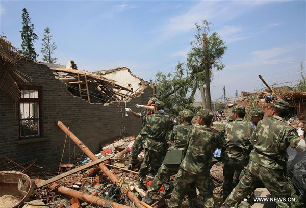 Soldiers dismantle a damaged house in Danping Village of Chenliang Township in Funing County of Yancheng City, east China's Jiangsu Province, June 25, 2016. Rain, hail and a tornado battered parts of Yancheng City on Thursday afternoon, destroying buildings, trees, vehicles and electricity poles. At least 98 people have died and 846 were injured. (Xinhua/Cai Yang)