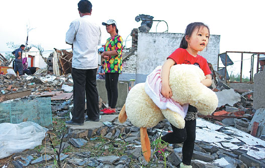 People sift through the debris of their homes on Saturday after a tornado hit Funing county, Jiangsu province. The death toll stood at 99, local authorities said on Sunday. Kuang Linhua / China Daily
