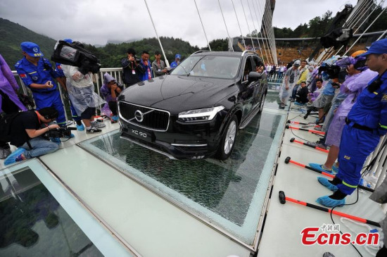 A SUV travels on a glass bridge during a load testing at the Grand Canyon of Zhangjiajie, central China's Hunan Province, June 25, 2016. The bridge is 430 meters long, six meters wide and 300 meters above the valley. (Photo: China News Service/ Yang Huafeng)