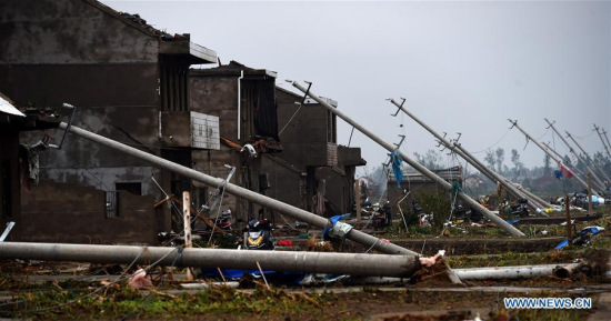 Photo taken on June 24, 2016 shows damaged houses and fallen wire poles in Danping Village of Chenliang Township in Funing, Yancheng, east China's Jiangsu Province. (Xinhua/Han Yuqing)