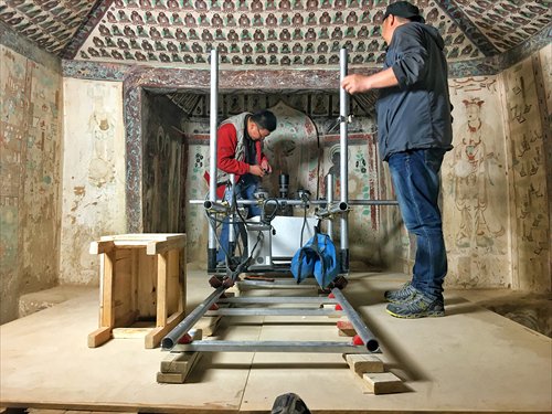 Staff scan a mural in the Mogao Caves in Gansu Province on May 31. (Photo: Li Jingjing/GT)