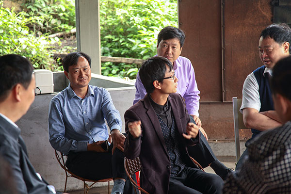 Gao Yunfu (with eyeglasses) introduces his cultivating edible fungus business to officials of Huichang county.