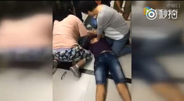 The screenshot from an online video shows passersby try to resuscitate Jin Bo, the deputy editor-in-chief of China's leading online forum Tianya, whose death on Wednesday prompted calls for increased public awareness of health risks posed by overwork.