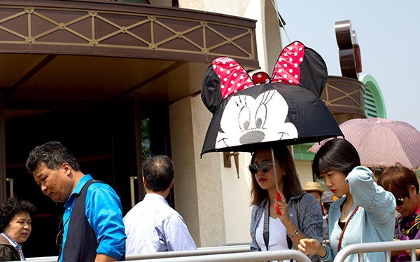 A Mini Mouse umbrella can't shorten the wait time of at least 30 minutes for shoppers at Disney's theme park in Shanghai after the park's soft opening in May. GAO ERQIANG/CHINA DAILY