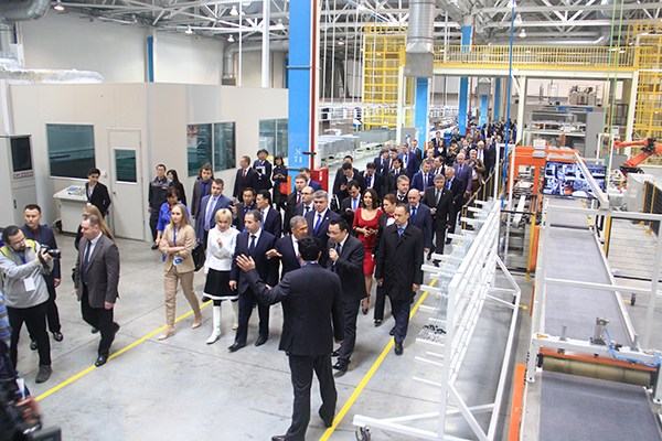 Local officials and businesspeople visit Haier's new refrigerator plant in Kamsky Industrial Park, Russia. (Photo provided to China Daily)