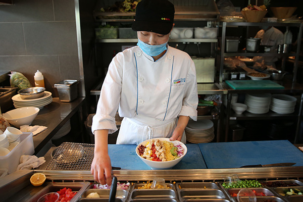 A cook makes a salad bowl in an Element Fresh restaurant in Beijing. (Wang Zhuangfei/China Daily)