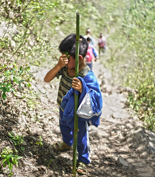 A child from Atuler village in Sichuan province on his regular long trudge to school. CHEN JIE/ FOR CHINA DAILY