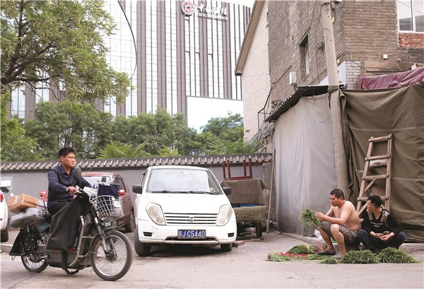 Dongxiejie Hutong is just a street away from Beijing's financial district, but people living in the hutong feel as if they are in a totally different world to those in the highrises.