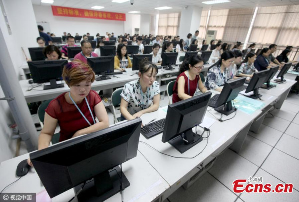 Exam markers look at test papers from this year's gaokao, the national college entrance exam, in Southwest China's Chongqing Municipality, June 11, 2016. (Photo/CFP)