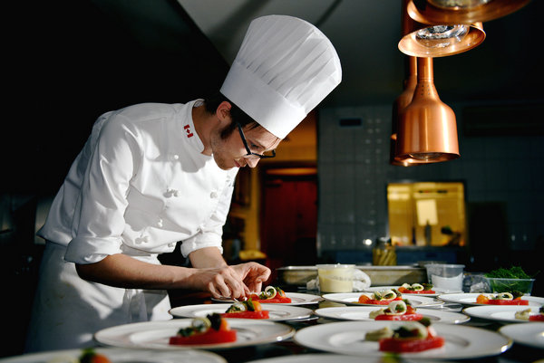 Chef Ethan Robinson prepares dishes for a wine-pairing dinner at the Canadian embassy in Beijing during the fifth Eat Drink Canada China. (Photo provided to China Daily)