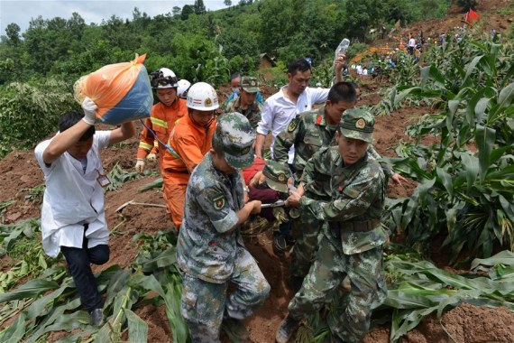 Rescuers transfer an injured person at the disaster site after a rain-triggered landslide hit Pianpo Village, Dafang County in the city of Bijie, southwest China's Guizhou Province, July 1, 2016. The landslide on Friday morning has caused 11 people dead and 12 missing. (Photo: Xinhua)