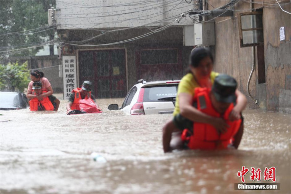 Firefighters carry residents to safety in Huangpi district, Wuhan, capital of Central China's Hubei province, July 1, 2016. The city was flooded in some parts and hundreds of residents were trapped after heavy rainstorms on July 1. The district firemen have rescued more than 150 trapped residents and evacuated more than 250. (Photo/chinanews.com)