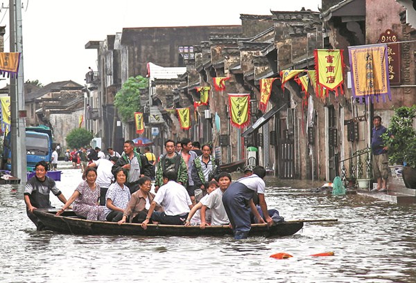 Residents are moved to safety on Sunday in Tongling, Anhui province, as flooding continued to affect the city and other regions in central and eastern China. (Photo by ZHAN JUN/FOR CHINA DAILY)