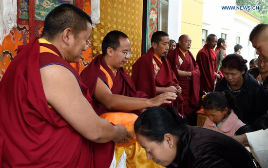  The 11th Panchen Lama (2nd L), Bainqen Erdini Qoigyijabu, touches the heads of Buddhism followers to give blessings during the Saga Dawa Festival in Lhasa, capital of southwest China's Tibet Autonomous Region, May 21, 2016. Buddha's birthday, April 15 according to Tibetan calendar, falls on May 21 this year and it's an important day of the festival. (Xinhua file photo/Chogo)