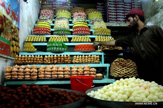 A man arranges traditional sweets at a bakery ahead of Eid al-Fitr festival in Pakistan's northwest Peshawar on July 5, 2016. Eid al-Fitr, a major Muslim holiday, marks the end of the holy month of Ramadan. (Xinhua/Ahmad Sidique) 