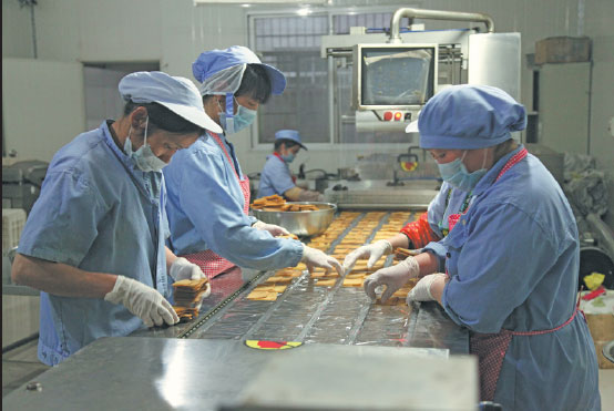 Workers at Song Ruisen's dried tofu factory in Huichang county, Jiangxi province. (Photos By Zhang Xiao / China Daily)