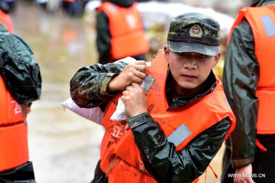 A soldier carries a sandbag to reinforce the Dadao dyke of Baidang Lake in Tanggou Township of Zongyang County, east China's Anhui Province, July 6, 2016. Over 260 soldiers were dispatched to reinforce the dyke. (Xinhua/Liu Junxi) 