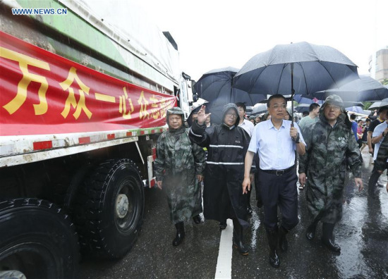 Chinese Premier Li Keqiang (2nd R, front) directs relief effort on the main dike of the Yangtze River in Wuhan, capital of central China's Hubei Province, July 6, 2016. (Xinhua/Pang Xinglei)