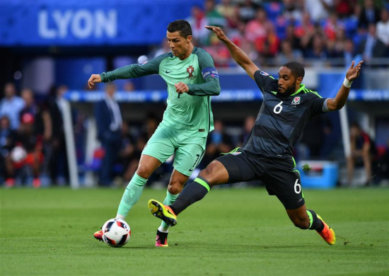 Cristiano Ronaldo of Portugal (L) vies with Ashley Williams of Wales during the Euro 2016 semifinal match between Portugal and Wales in Lyon, France, July 6, 2016. (Xinhua/Tao Xiyi)