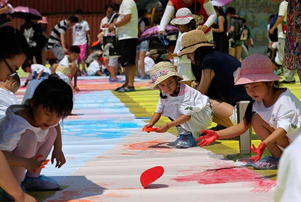 Children paint an Arabian horse on a canvas of 1,200 square meters for the show Cavalia in Beijing.(Photo by Feng Yongbin/China Daily)