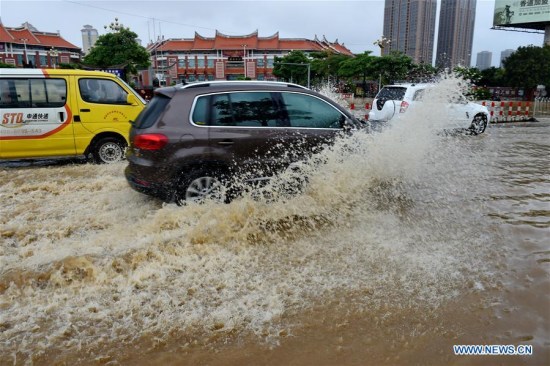 Vehicles run on a flooded road in Putian City, southeast China's Fujian Province, July 9, 2016. 