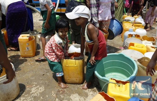 A girl and a boy carry water with a bucket after collecting the water from donors at Dala Township on the outskirts of Yangon, Myanmar, April 28, 2016. (Xinhua/U Aung)