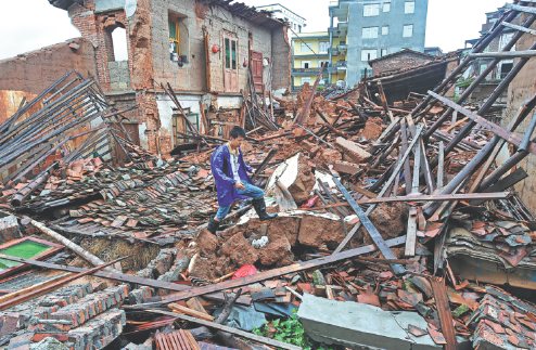 A resident assesses his losses at his collapsed home in Putian, Fujian province, after typhoon Nepartak made landfall on Saturday. (Photo/Xinhua)